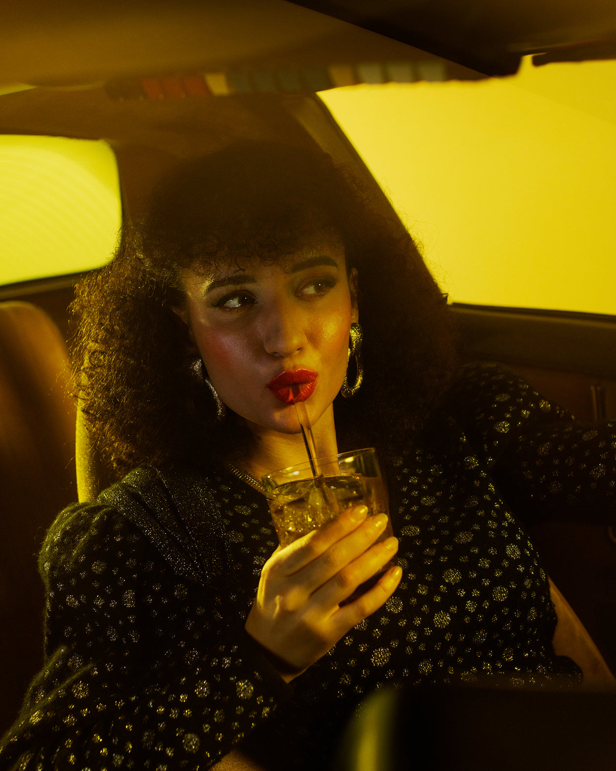 Woman sipping TURBO BOOST energy drink in car.