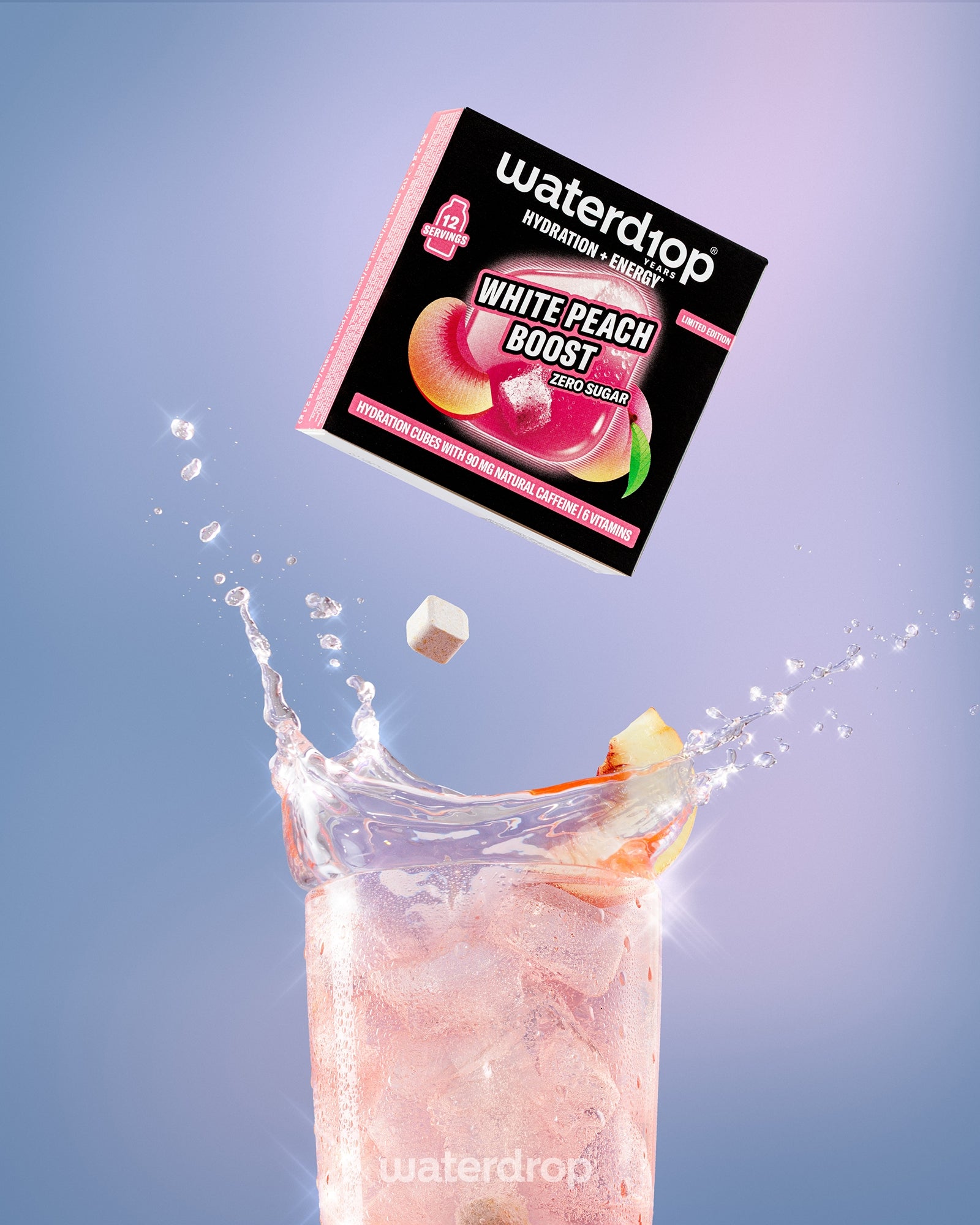 Кутија напиток White Peach Boost над висока чаша со розева пијалок и коцка мраз.